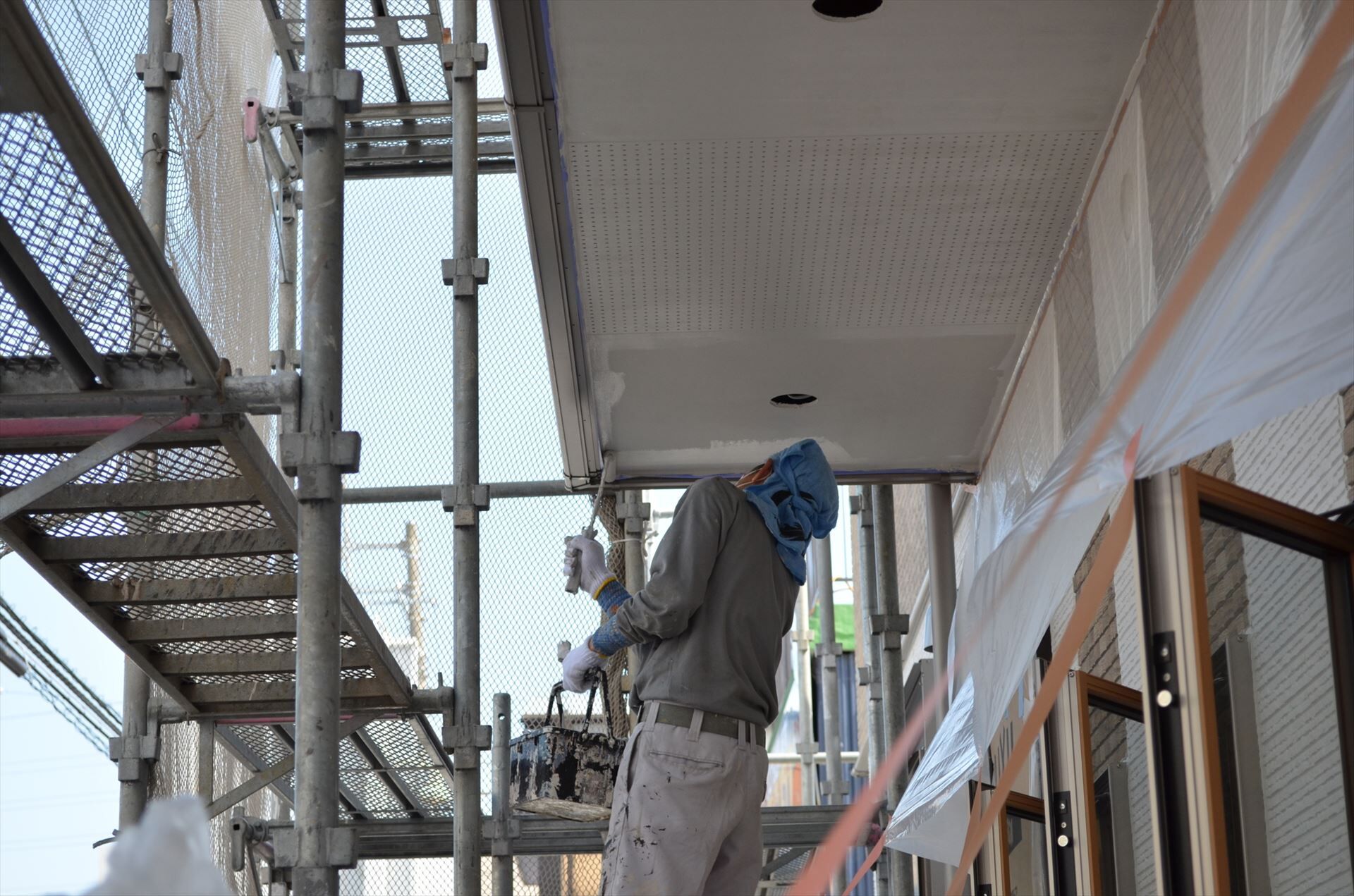 軒天塗装するスタッフ